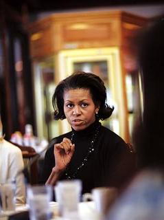 Michelle Obama speaking to unknown addressee at a table she looks stern and serious