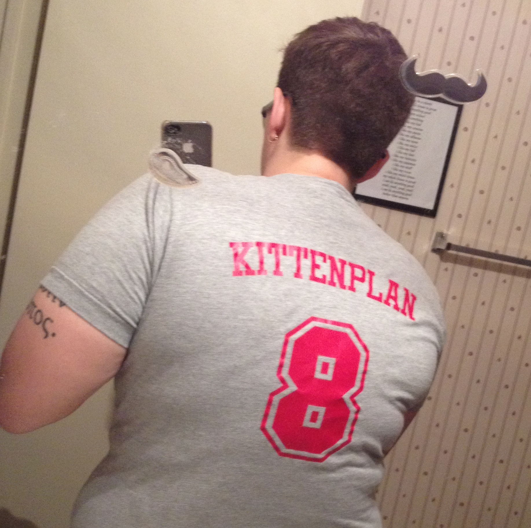 Kendall wearing a gray tshirt with "KITTENPLAN" and "8" written on the back in red lettering