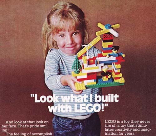 A girl holds up a chaotic lego set. Text across the image reads "Look what I built with LEGO." Smaller text reads "And look at that look on her face. That's pride smiling" and "LEGO is a toy they never tire of, a toy that stimulates creativity and imagination for years."