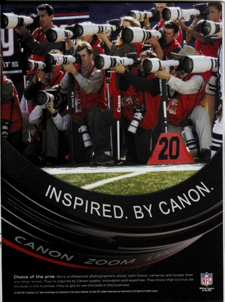 Cannon advertisement photograph of photographers taking pictures with the red vests on.  The text reads: Inspired.  By Cannon.