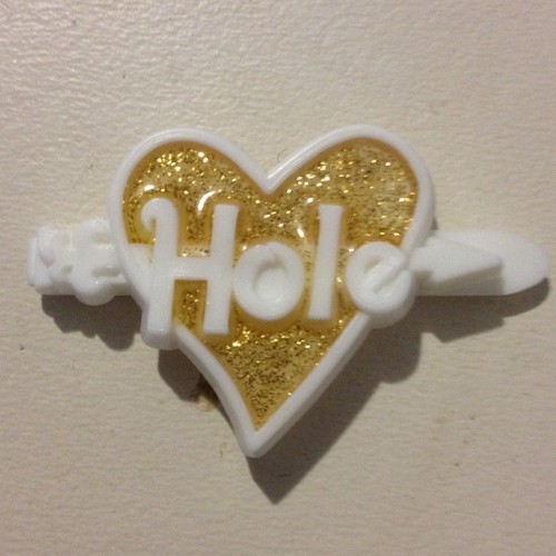 A sparkly barrette heart with "Hole" written inside.