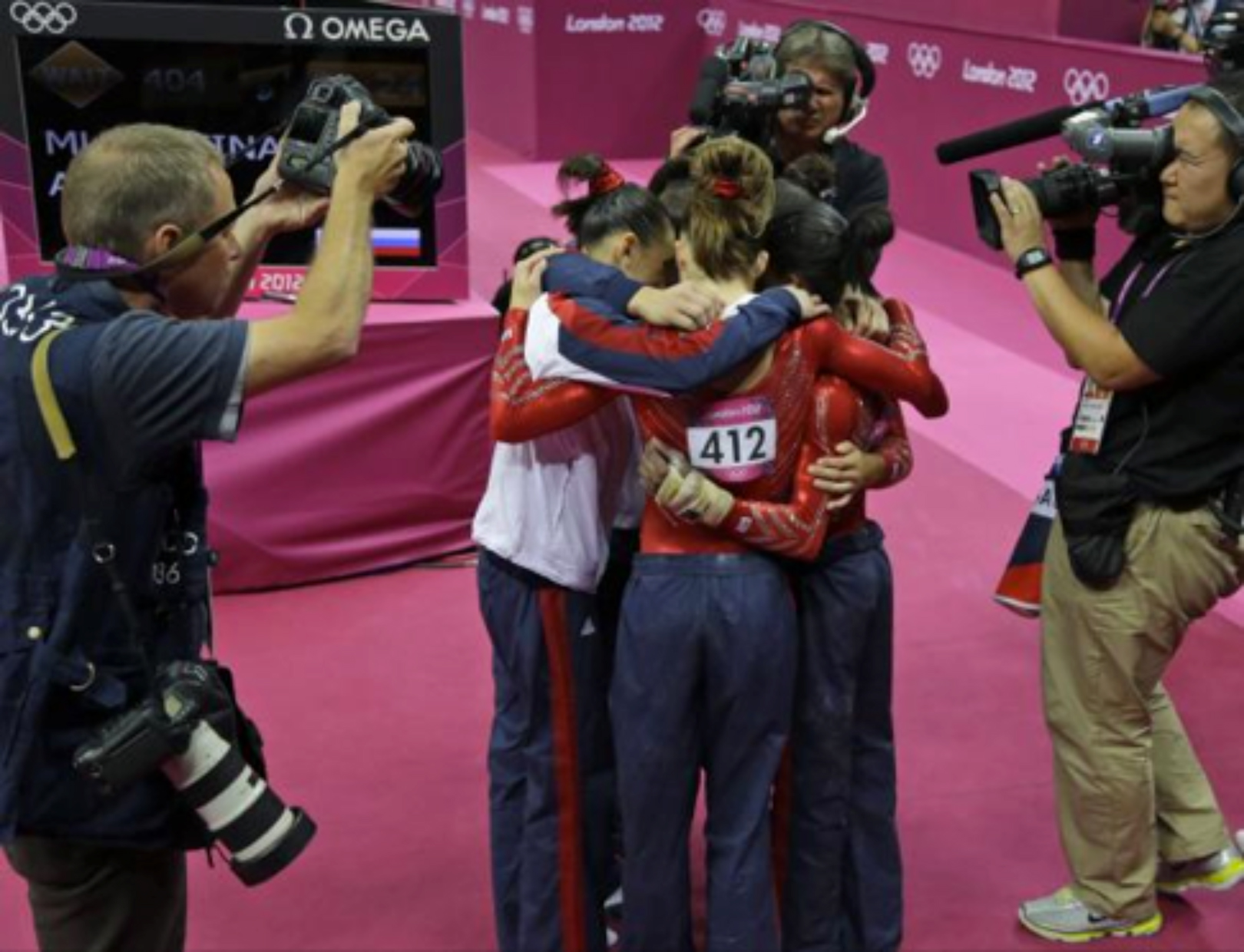 An unconventional shot of the victorious US women's gymnastics team that shows paparazzi swarming the victors