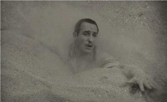 George Valentin disappearing under quicksand; only his head remains above and one of his hands, reaching out