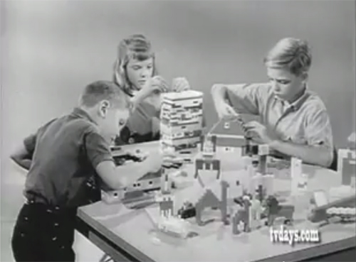 Three children (two boys and one girl) play with legos at a single table.
