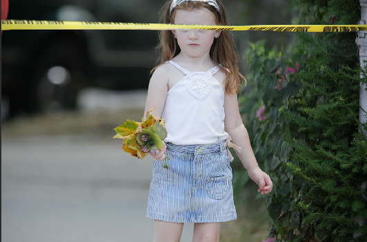 Little girl's eyes blocked by crime scene tape