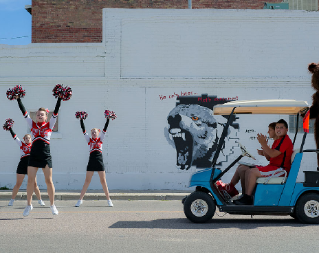 cheerleaders with a golf cart coming toward them