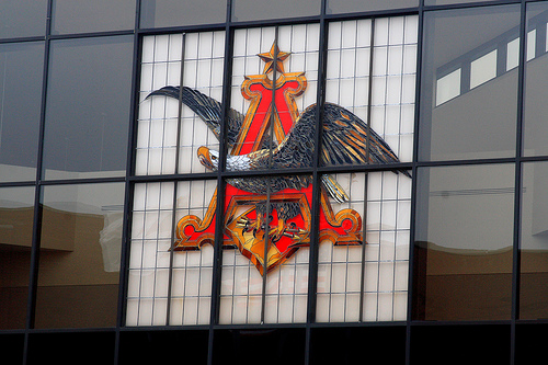 Anhauser-Busch logo; eagle perched beneath a large red A clutching arrows and standing on shield