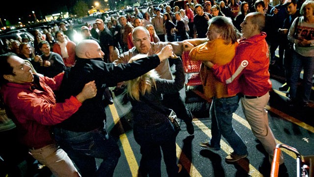A security guard pulls apart Black Friday brawlers