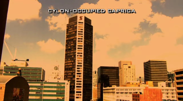 Caprica: Subtitled "Cylon Occupied Caprica" over tall skyscrapers 