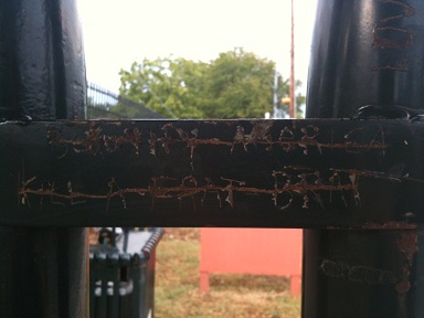graffiti phrase scratched through on bus station pole saying kill a frat brat