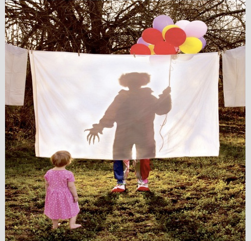child before scary clown shadow