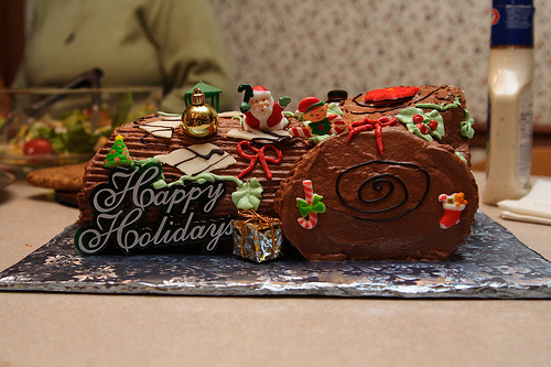Edible chocolate yule log with Santa & elves & sign: "Happy Holidays"