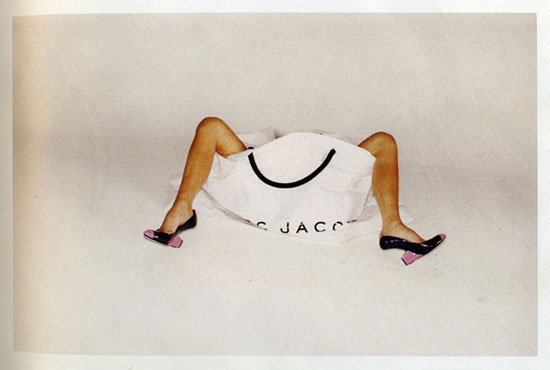 A large Marc Jacobs shopping bag with two legs sticking out with highs heels on.