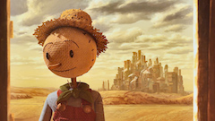 a friendly looking scarecrow with an industrial and polluted city as a backdrop